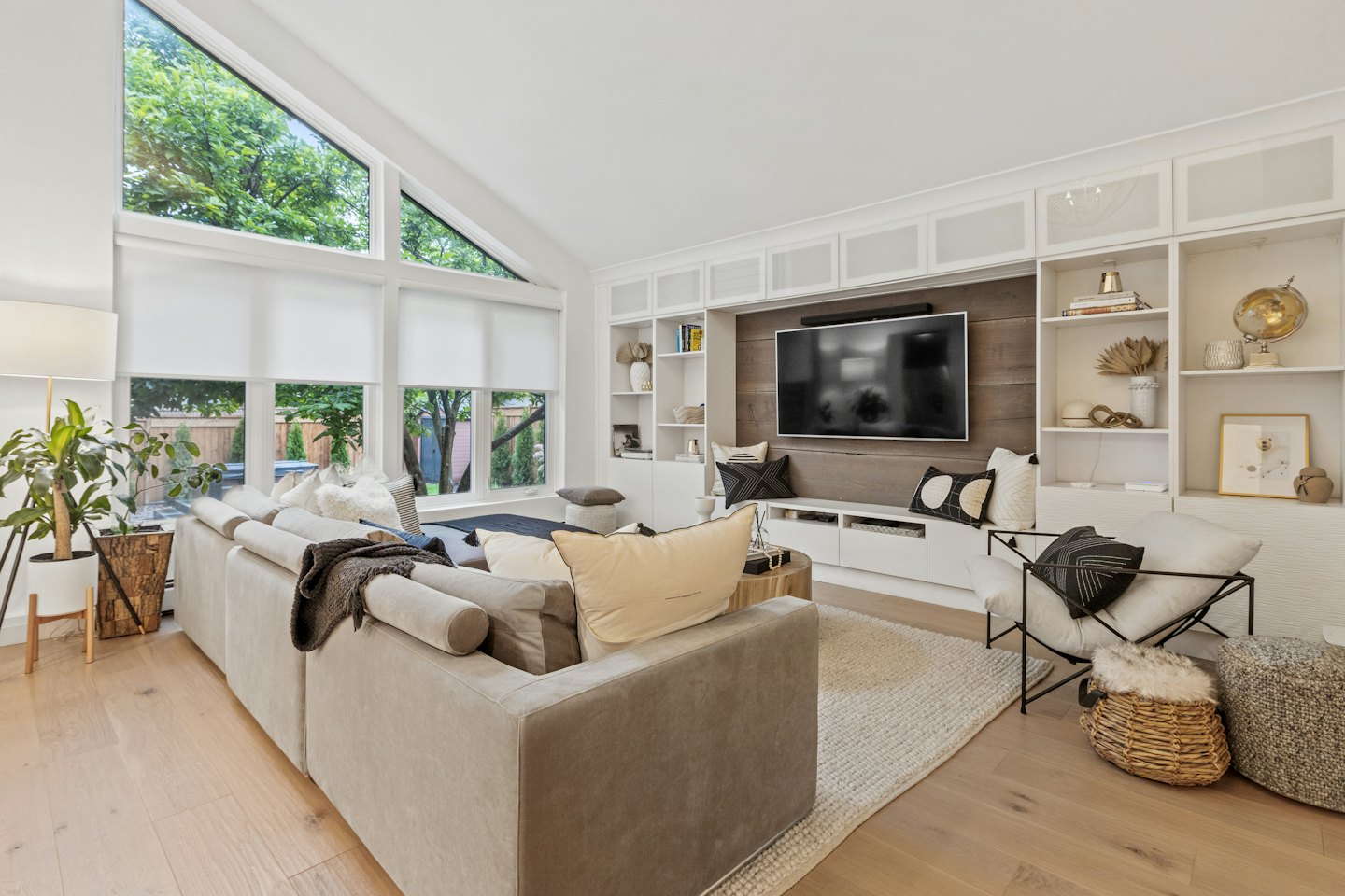Living room with L-shaped sofa and abundant built-in shelves.